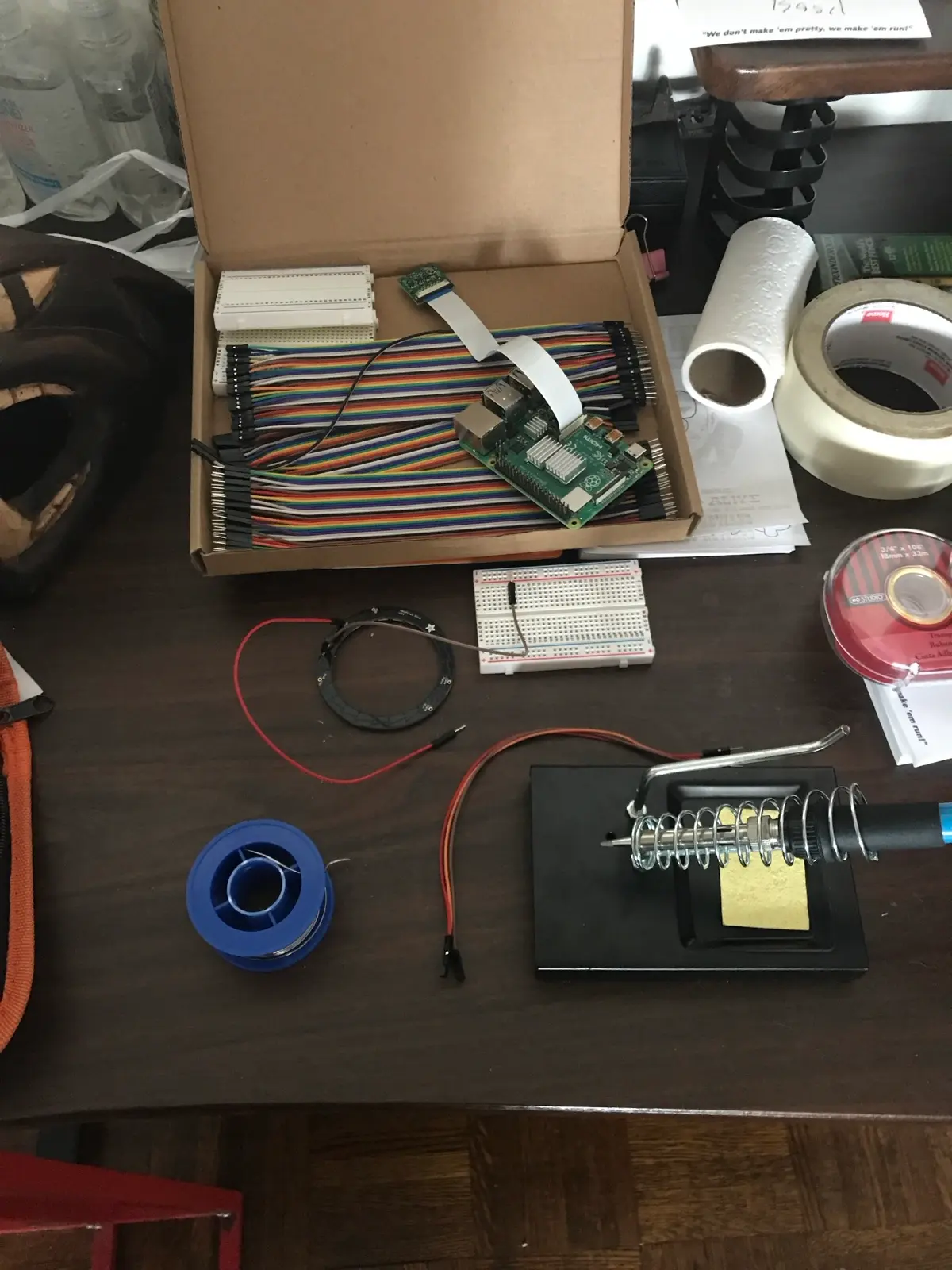 Parts on the desk: Raspberry Pi, ribbon cables, breadboard, and soldering iron