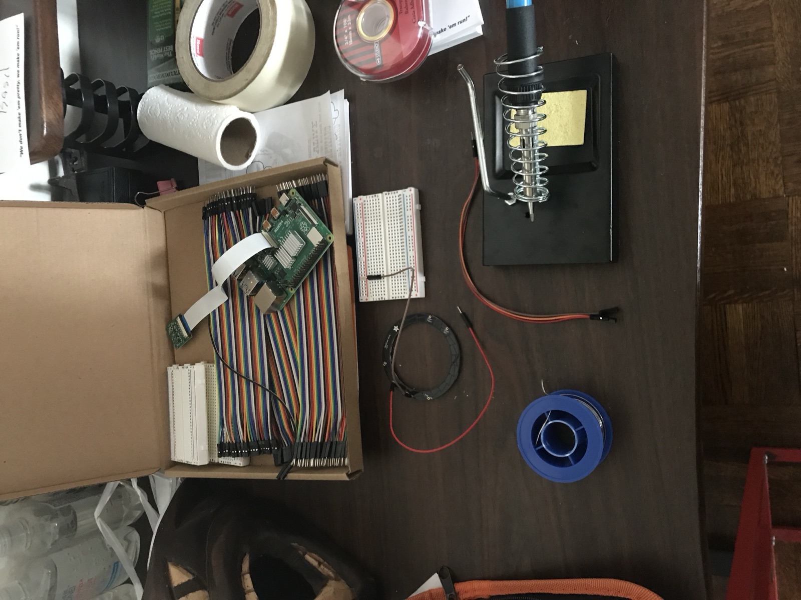 Parts on the desk: Raspberry Pi, ribbon cables, breadboard, and soldering iron