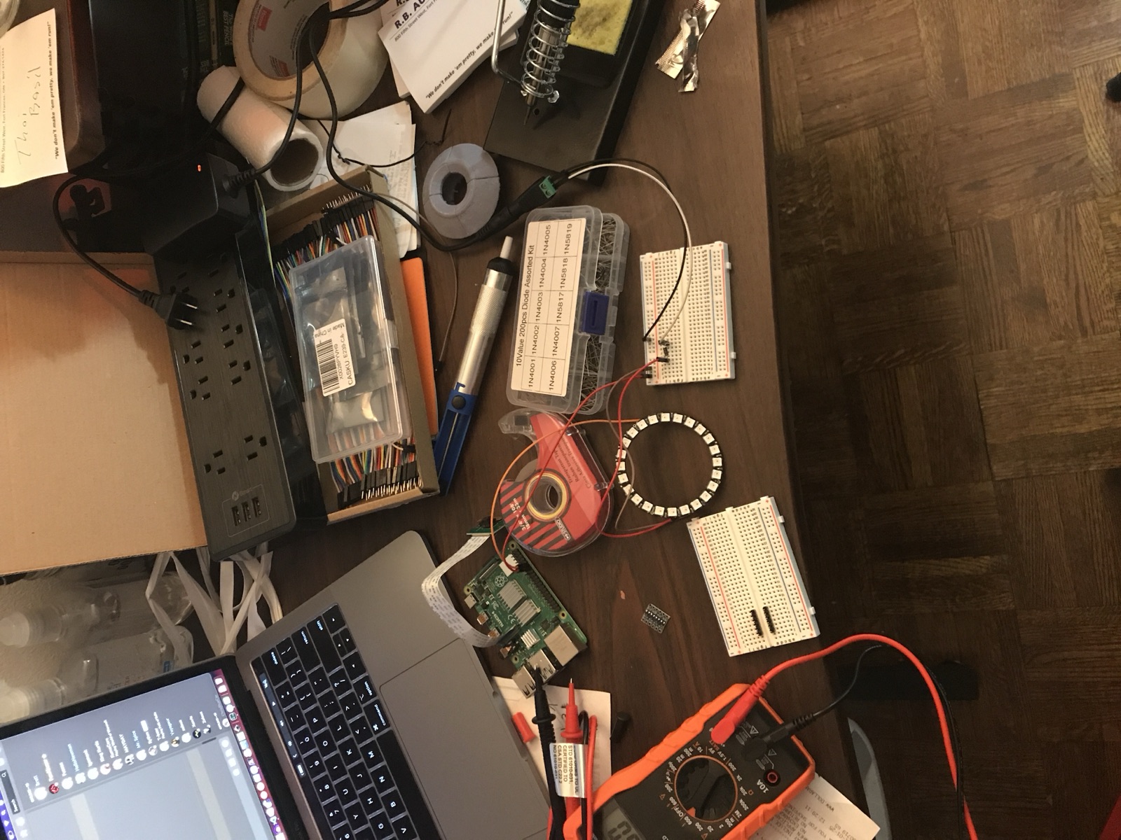 NeoPixel ring wired up on the bench with breadboards and a multimeter